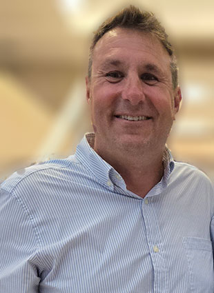 Doug Ryner, a well-known figure in the tech industry,smiling at the camera.